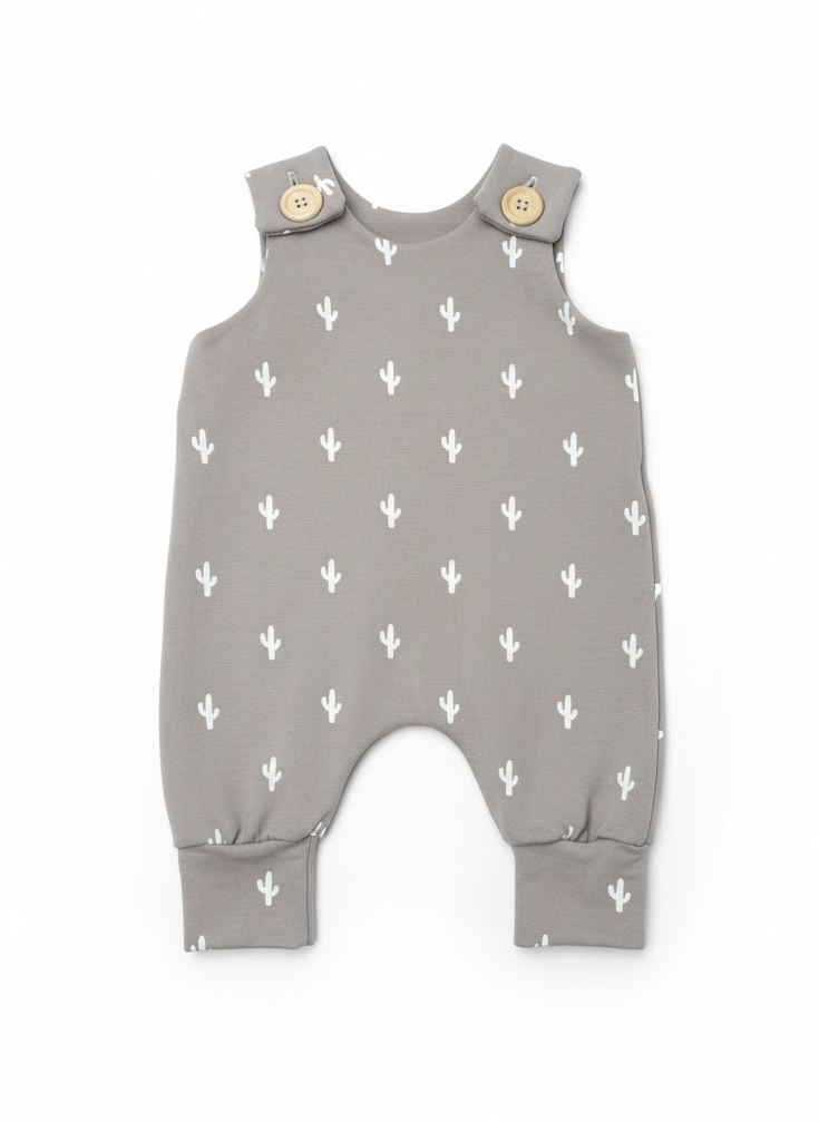 Cream cactus on grey background print baby romper with button closures on a white background. Designed with room to grow for longer wear