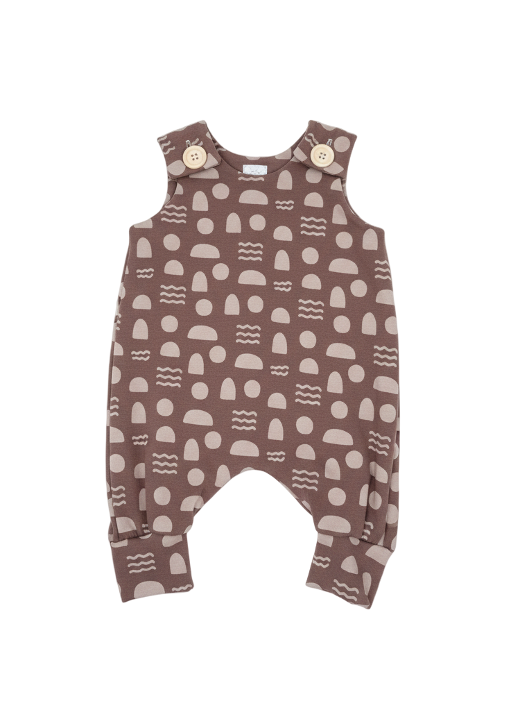 Mocha baby romper with button closures on a white background. Geometric shapes and wavy lines in cream. Designed with room to grow for longer wear